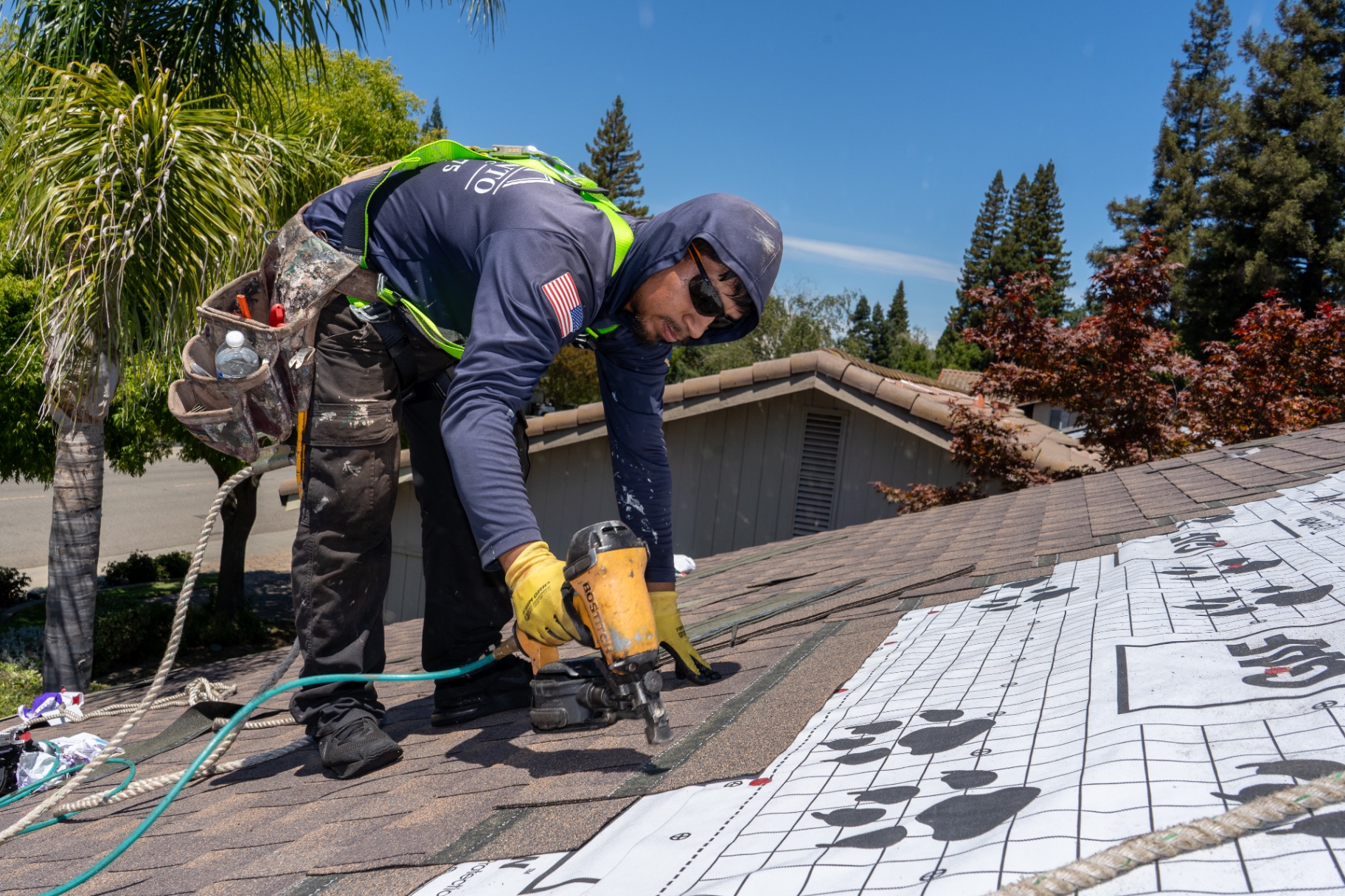Sacramento Roofing Inc crew installing replacement asphalt shingles on a Sacramento home