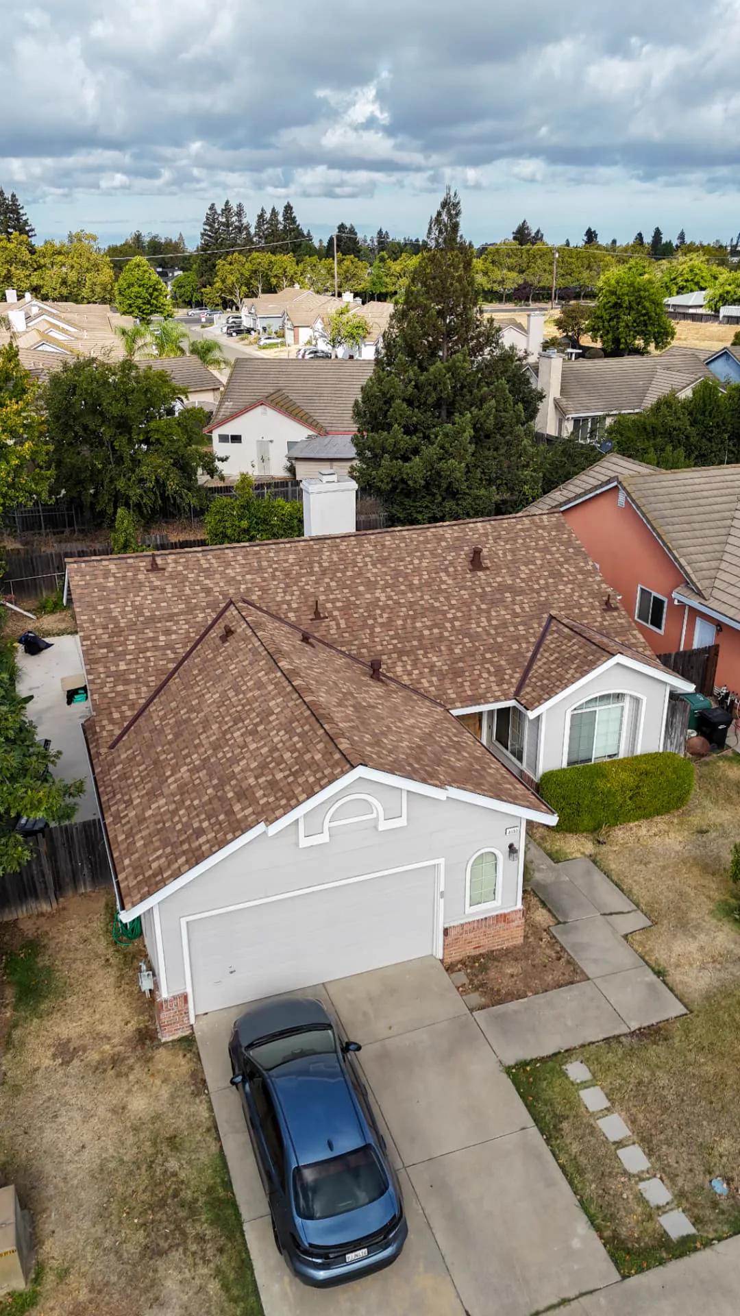 Vertical drone view of a newly completed brown architectural shingle roof in the Sacramento area