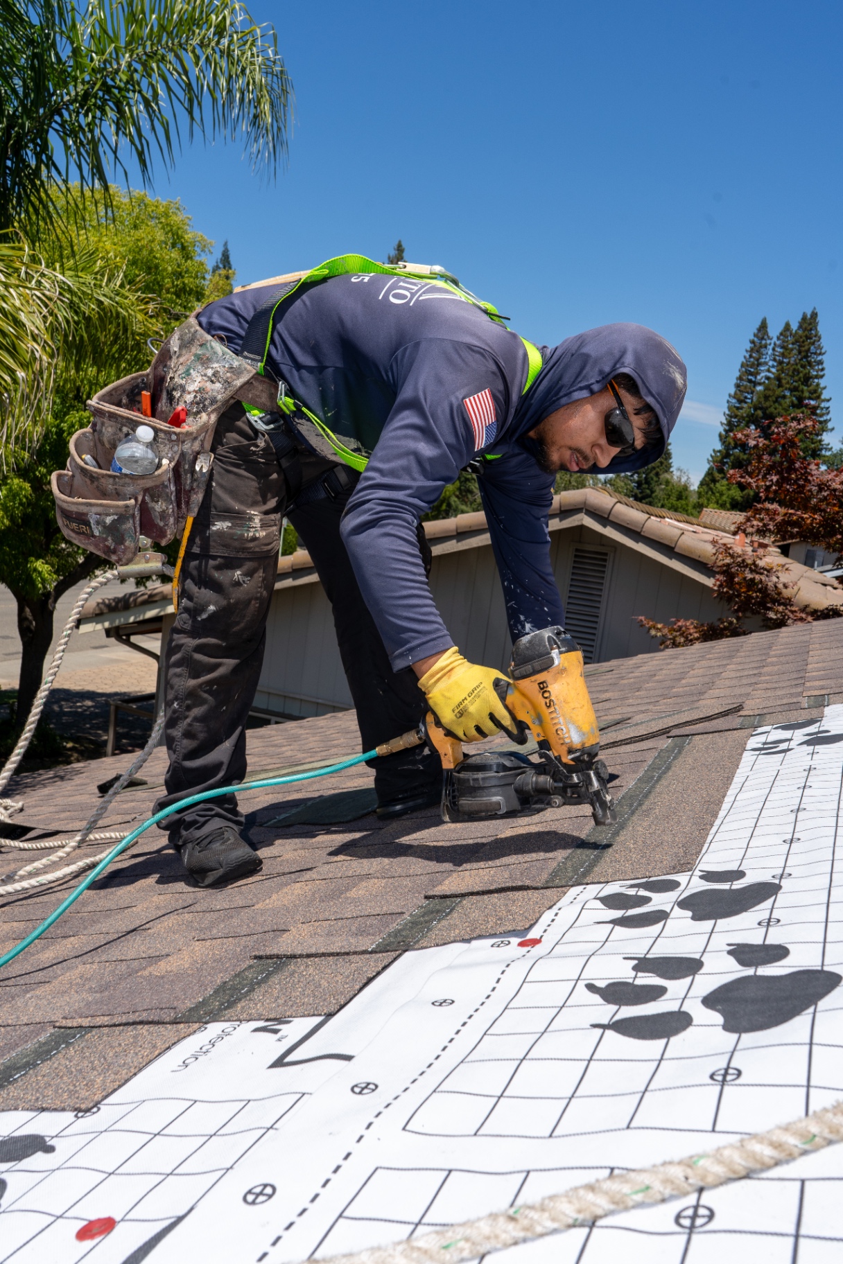 Roofing team installing new shingle courses on a Sacramento home
