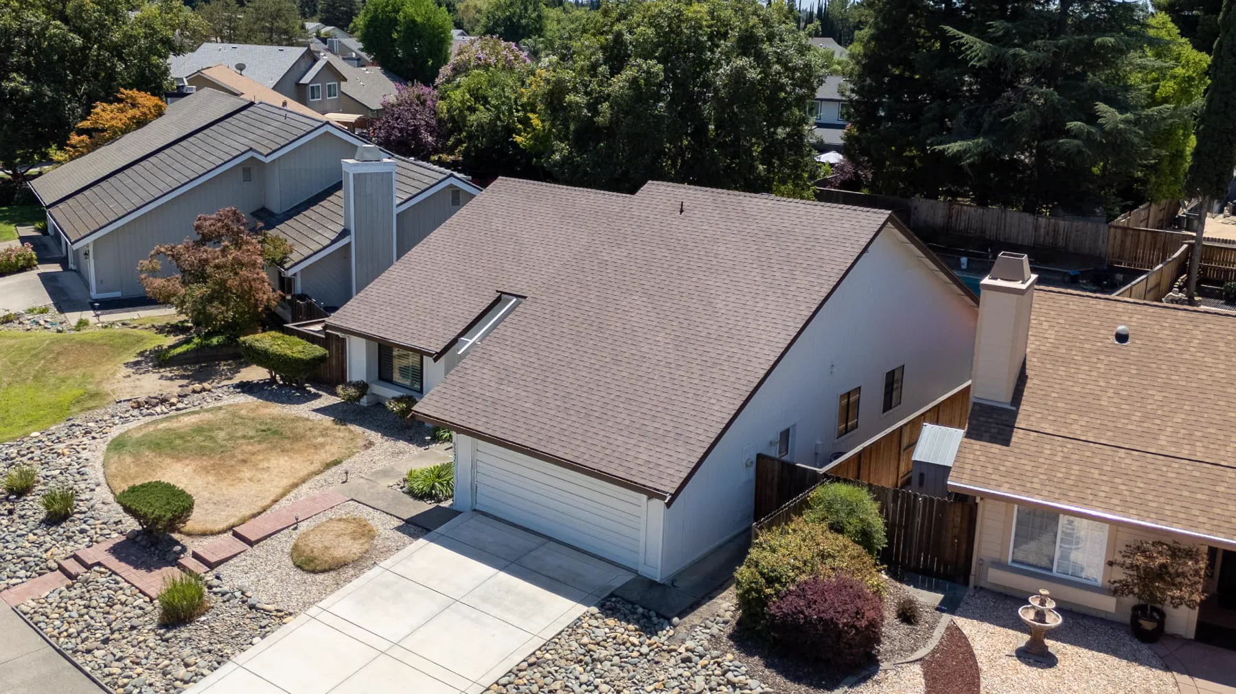 Three-quarter drone view of a completed brown architectural shingle roof on a Sacramento-area home