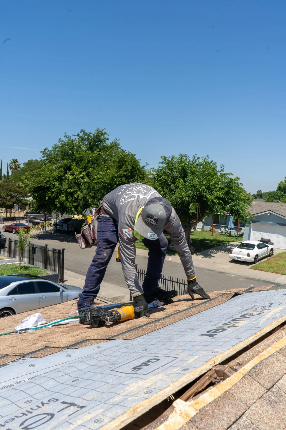 Roofer working on flashing and ridge details during a Sacramento roof repair